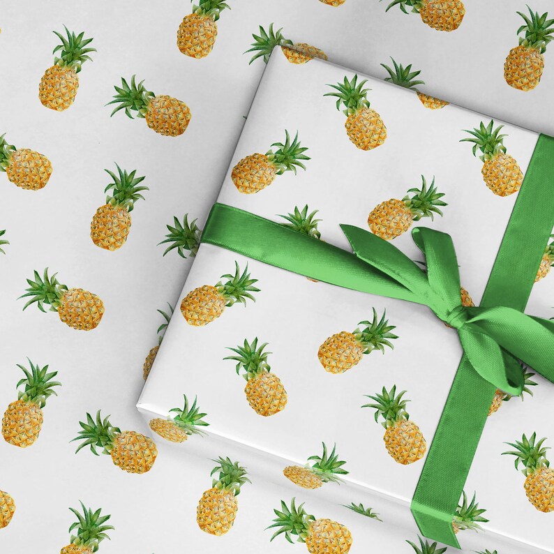 May include: White gift wrap with a green ribbon and a repeating pattern of yellow pineapples.