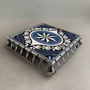 vintage tile trivet on decorative stainless steel frame