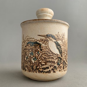 Może przedstawiać: Biały ceramiczny słoik z pokrywką i brązowo-niebieskim wzorem ptaków i kwiatów.