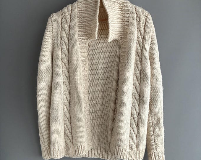 Hand-knit cream cable-knit cardigan with a shawl collar.