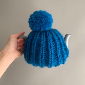 hand knitted tea cosy and ceramic tea pot