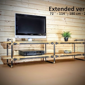 May include: A black metal and wood TV stand with two shelves. The stand is 72" - 114" (180 cm - 290 cm) long. The stand has a black TV on the top shelf and a black DVD player on the bottom shelf.