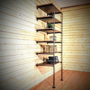 May include: A six-shelf industrial pipe shelving unit with wooden shelves. The shelves are empty except for the third shelf, which has a wicker basket, and the fifth shelf, which has a stack of folded towels.