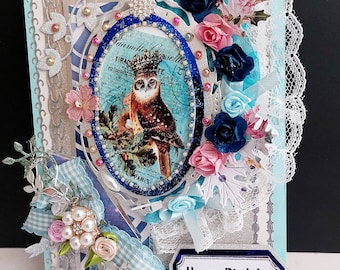 Tarjeta de cumpleaños del búho coronado. Tarjeta personalizada de lujo de Amor y Sabiduría en diseño 3D. Tarjeta azul plateada con cintas, broche, flores y perlas.