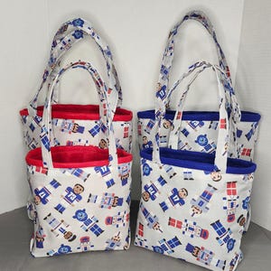 May include: Four small tote bags with white fabric printed with blue, red, and tan toy soldier figures. The bags have matching handles and a contrasting red or blue interior lining. The bags are suitable for carrying small items.