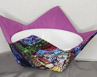 Könnte beinhalten: Eine Stoff-Schüssel-Hülle mit lila Innenfutter und einer farbenfrohen Außenseite mit einem Buntglas-Design. Die Hülle ist für eine weiße Schüssel konzipiert. Das Außendesign enthält Bilder von Charakteren.