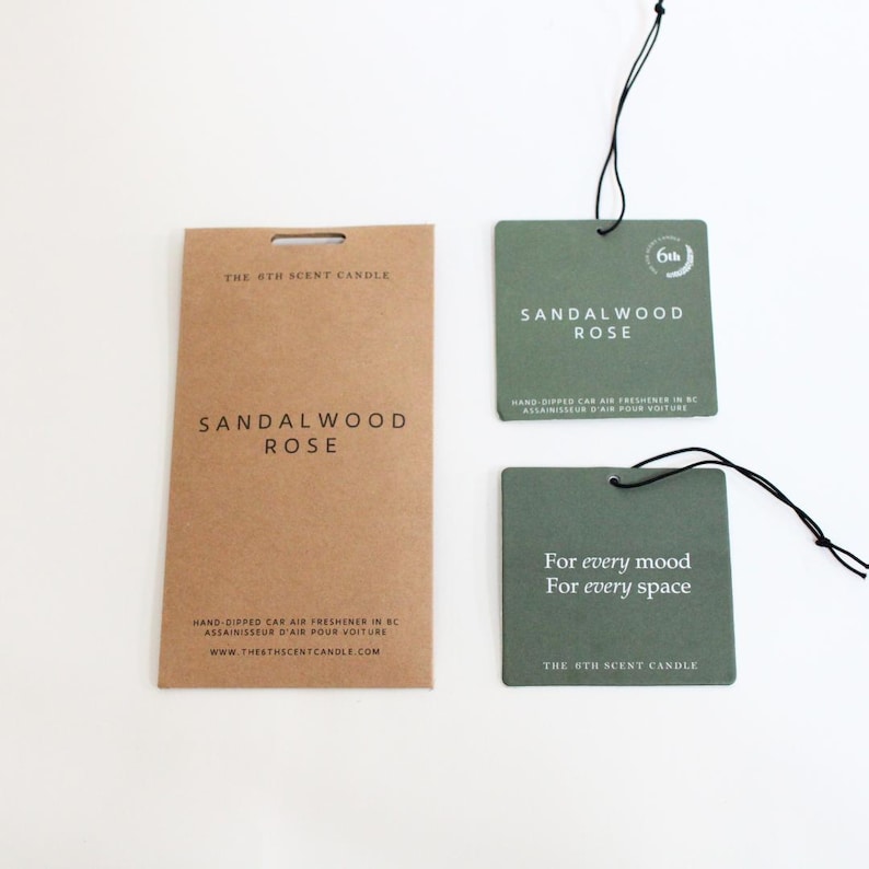 Puede incluir: Dos ambientadores de coche marrones y verdes con el texto "The 6th Scent Candle" y "Sandalwood Rose". Los ambientadores est&aacute;n hechos a mano y fabricados en BC, Canad&aacute;.