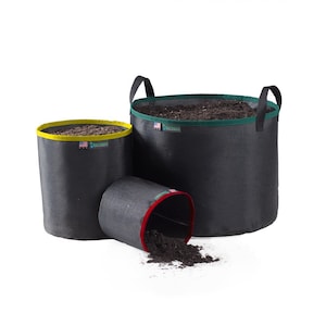 May include: Three black fabric grow bags of varying sizes, filled with soil. The largest has black handles and a green rim. The middle bag is tipped over, spilling soil. The smallest has a yellow rim. All have a small tag with text and an American flag.