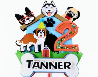 May include: A blue and brown dog house cake topper with a dog wearing a party hat, a bone, and the number 2 with glitter. The topper also includes the name Tanner.