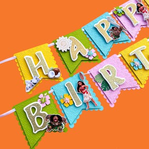 May include: A colorful banner with the words "Happy Birthday" in gold glitter letters. Each letter is on a separate card with a different design and character from the movie Moana.