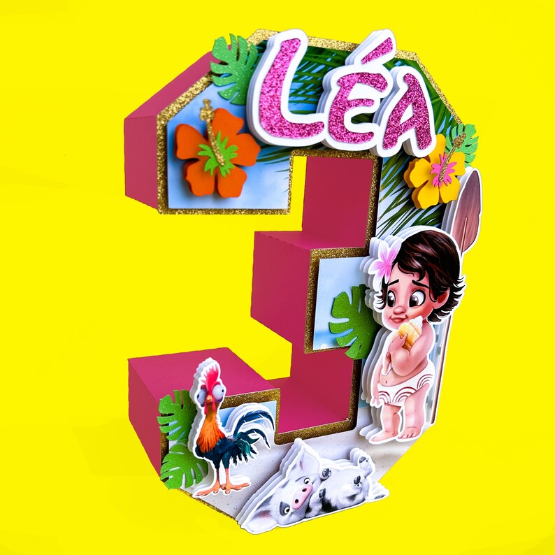Puede incluir: Decoraci&oacute;n de cumplea&ntilde;os con el n&uacute;mero tres en rosa con el nombre "L&eacute;a" en purpurina rosa. La decoraci&oacute;n presenta personajes de dibujos animados, flores y hojas tropicales. El fondo es amarillo.