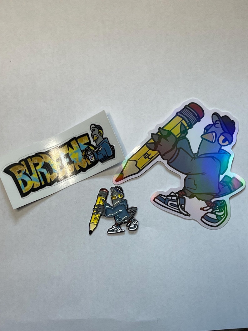 May include: Three stickers featuring a cartoon pigeon with a yellow pencil. One sticker has the word "BURDENE" in yellow and blue letters. The other two stickers feature the pigeon holding a yellow pencil, one is larger than the other.