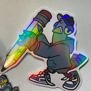 May include: A holographic sticker of a blue bird wearing a baseball cap and holding a yellow pencil. The bird is wearing a blue jacket and sneakers.