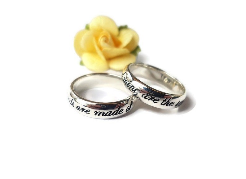 May include: Two silver rings with the words "Girls are made of" and "dreams are the dust" engraved on them.