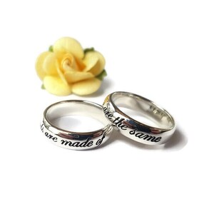 May include: Two silver rings with the inscription "We are made of the same" and "We are the same" on them.