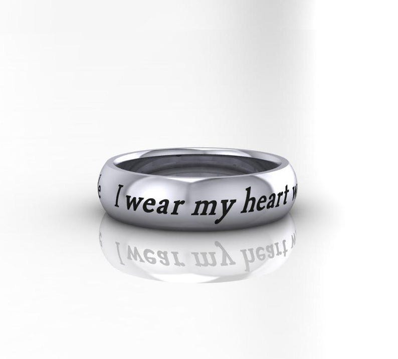 May include: A silver band ring with the inscription "I wear my heart on my sleeve" engraved on the outside.