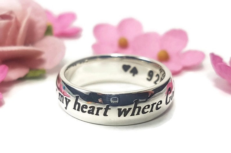 May include: A silver ring with the inscription "You are my heart where God"