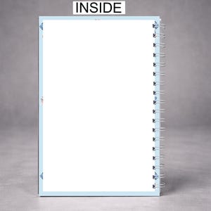 May include: A spiral-bound notebook with a light blue border and white pages. The word "INSIDE" is printed in black at the top. The notebook is open, revealing blank pages, and is set against a gray background.