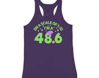 May include: Purple racerback tank top with a green and purple graphic that says "On a scale of 1-10 I'm a 48.6" with a purple and green elf hat on top of the 8.