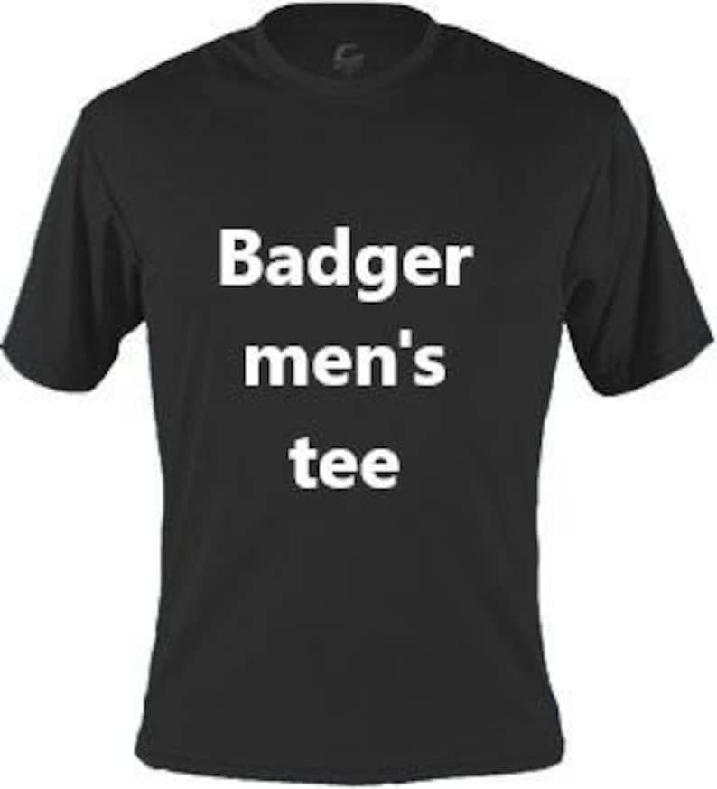 May include: Black short-sleeved tee shirt with the text "Badger men's tee" in white block letters. The shirt has a crew neck and is made of a soft, breathable material. The shirt is a solid black color.