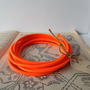 Mooi canvas rond elektriciteitskabel met fluor oranje kleur jute bekleed. Canvas snoer van jute en 2 binnendraden van 0,75 mm