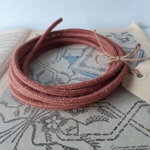 Mooi canvas rond elektriciteitskabel met oranje klei kleur jute bekleed. Strijkijzersnoer van canvas en 2 binnendraden van 0,75 mm