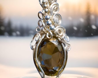 May include: A silver wire wrapped pendant featuring a large, faceted, dark brown gemstone. The pendant is set against a snowy background.