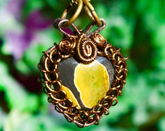 May include: A heart-shaped pendant with a yellow and black agate stone set in a wire-wrapped frame. The pendant is made of brass and has a delicate chain.