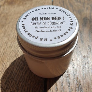 Peut inclure: Une petite boîte en argent avec une étiquette blanche qui indique "Beurre de karité • Bicarbonate de soude" et "Oh Mon Deo! Crème de Déodorant Naturelle et efficace Au beurre de karité".