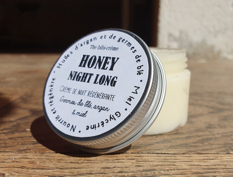 May include: A silver jar with a white label that reads "Honey Night Long Creme de Nuit Regenerante Germes de ble, argan & miel Glycerine  Nourrit et regenere Huiles d'argan et de germes de ble Miel".