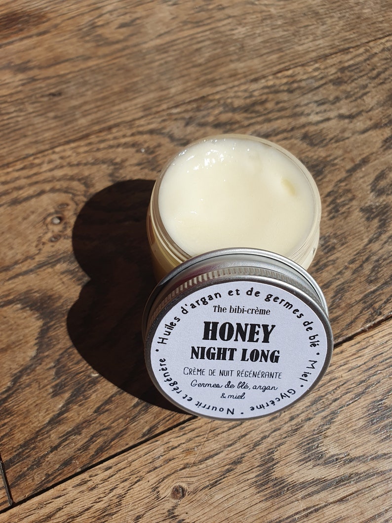 May include: A white jar with a black and white label that reads "The bibi-cr&egrave;me Honey Night Long Cr&egrave;me de Nuit R&eacute;g&eacute;n&eacute;rante Germes de bl&eacute;, argan & miel".