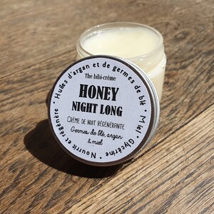 May include: A silver jar with a white label that reads "Honey Night Long Creme de Nuit Regenerante Germes de ble, argan & miel Nourrit et Regenerate Huiles d'argan et de germes de ble The bibi-creme"
