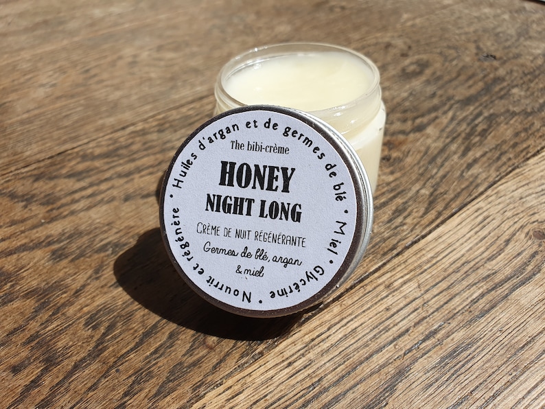 May include: A silver jar with a white label that reads "Honey Night Long Creme de Nuit Regenerante Germes de ble, argan & miel Nourrit et Regenerate Huiles d'argan et de germes de ble The bibi-creme"