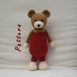 May include: A crocheted brown bear wearing a red crocheted outfit. The bear has white crocheted feet and hands. The bear is sitting on a white surface. The text "Pattern" is written in red on the left side of the image. The text "Kirpito" is written in black on the right side of the image.