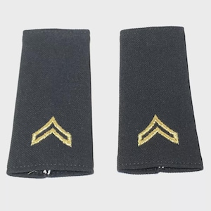 May include: A pair of dark navy blue shoulder boards with gold chevron rank insignia. The rectangular boards have a slightly textured appearance and are designed for military or uniform use.