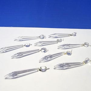 Pode incluir: Prismas de candelabro de cristal transparente com bordas facetadas e detalhes de cristal redondos. Estes prismas decorativos de vidro são projetados para refletir a luz e adicionar brilho a candelabros e outras luminárias.