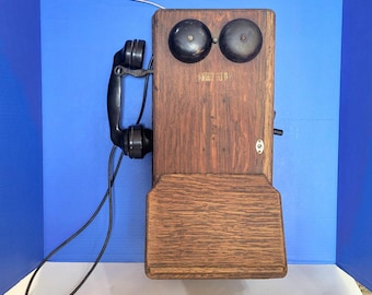 Teléfono de pared antiguo de madera con manivela