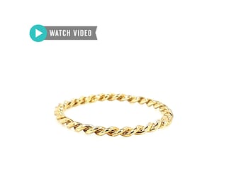 May include: A gold-colored twisted ring. The ring is simple and delicate.