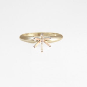 May include: A gold ring with a six-prong setting for a center stone.
