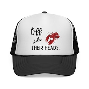 May include: A black and white trucker hat with a white front panel. The front displays the text "Off with THEIR HEADS" and a red lobster illustration. The hat has a black peak and mesh back.