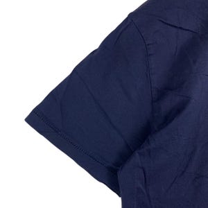 May include: A short-sleeved t-shirt in a solid dark navy blue colour. The garment features a simple crew neckline and a straight hemmed sleeve edge with visible stitching detail along the cuff. The fabric appears smooth and lightweight.