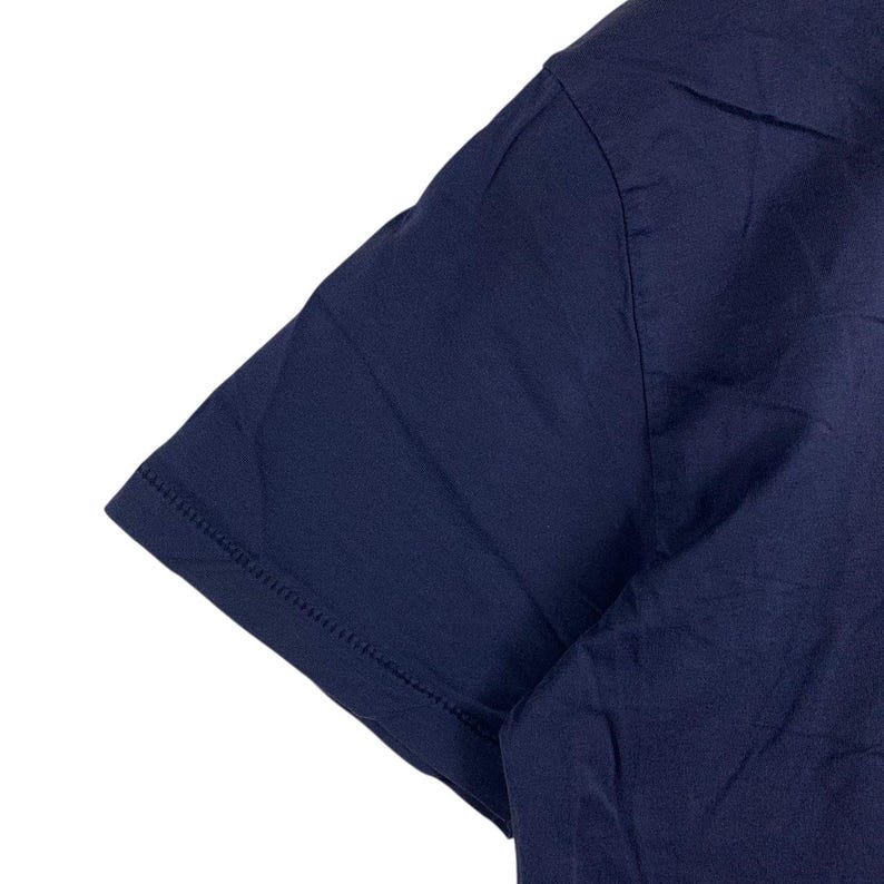 May include: A short-sleeved t-shirt in a solid dark navy blue colour. The garment features a simple crew neckline and a straight hemmed sleeve edge with visible stitching detail along the cuff. The fabric appears smooth and lightweight.