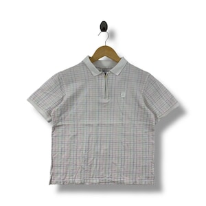 May include: A short-sleeved polo shirt with a white collar and a quarter-length zipper. The shirt features a plaid pattern in red, blue, and green on a white background. A small logo is visible on the chest.