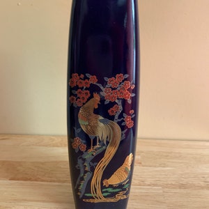 May include: A cobalt blue ceramic vase with a gold rim and a Japanese-inspired design featuring a rooster and a hen with gold and red accents.