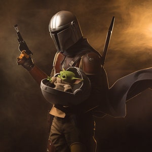 May include: A Mandalorian warrior in a silver helmet and brown armor holds a small green alien in a floating pod. The warrior is holding a blaster pistol in one hand and has a cape flowing behind him. The scene is set against a dark background with a bright orange light in the distance.