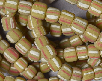 May include: A close-up of a string of yellow and white striped glass beads with red accents. The beads are cylindrical and have a matte finish.