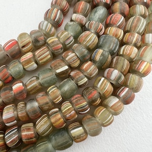May include: A strand of colorful glass beads with a striped pattern. The beads are translucent and have a variety of colors, including red, orange, yellow, green, and blue.
