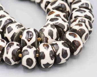 May include: A strand of black and white patterned beads. The beads are round and have a smooth, polished finish.