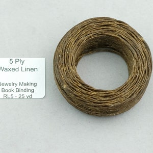 May include: A spool of 5 ply waxed linen thread, brown in color. The label reads "5 Ply Waxed Linen, Jewelry Making Book Binding, RL5 - 25 yd".