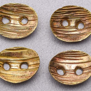 May include: Four gold-toned metal buttons with a textured, wavy surface and two holes each.